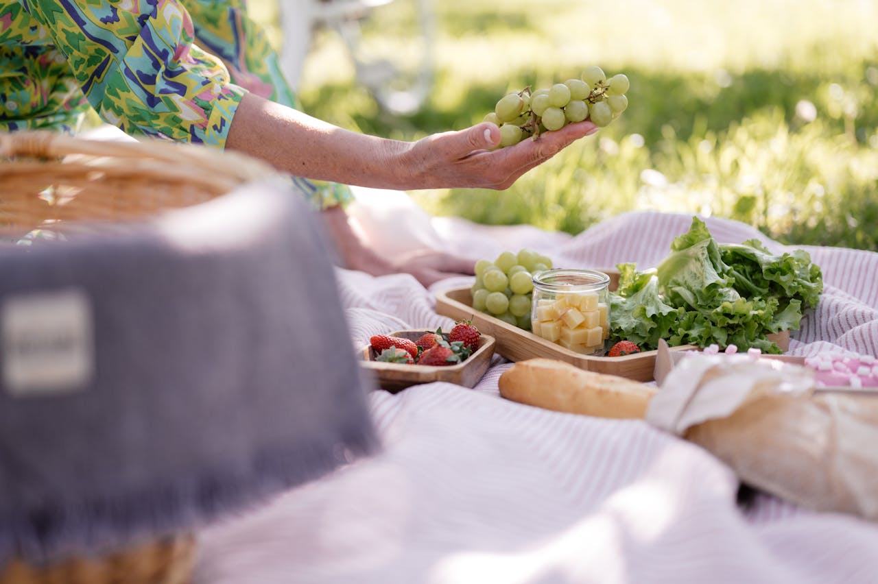 The Art of Drawing Readers In: Your attractive post title goes here A vibrant picnic scene with fresh grapes, strawberries, and greens outdoors.